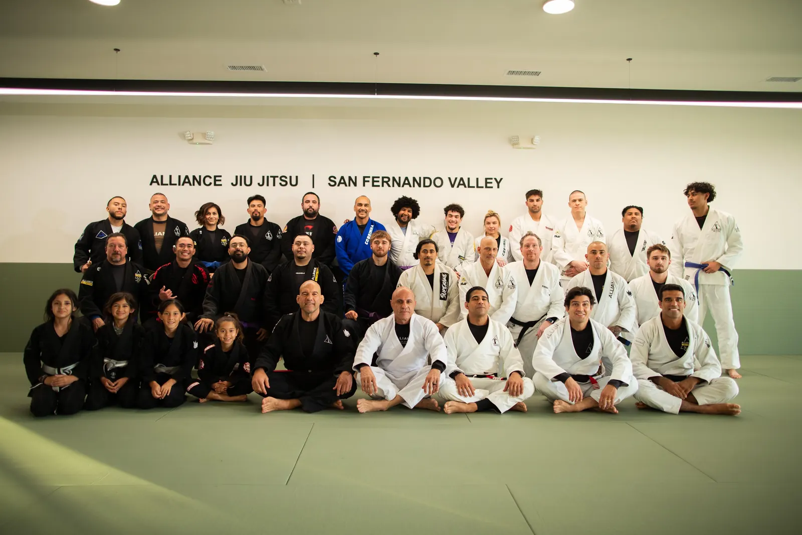 The Alliance Jiu-Jitsu San Fernando Valley team in front of the academy wall